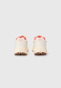 Fottøy med en krem og dempet rosa fargepalett, med en teksturert overflate og fremtredende såle som viser Vibram-logoen.
