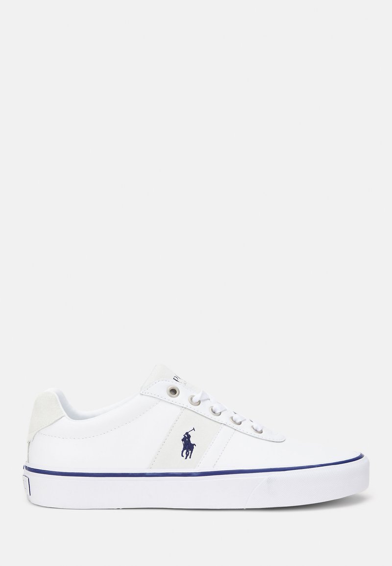 Hvit sneakers med en glatt skinnoverdel, rund tå, marineblå detaljer og en logodetalj på siden. Har snøring og gummisåle.