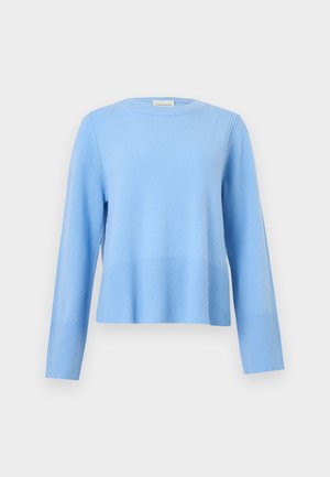 Ανοιχτό μπλε πουλόβερ με στρογγυλή λαιμόκοψη, μακριά μανίκια και ριμπ μανσέτες και τελείωμα σε απλό γκρι φόντο.