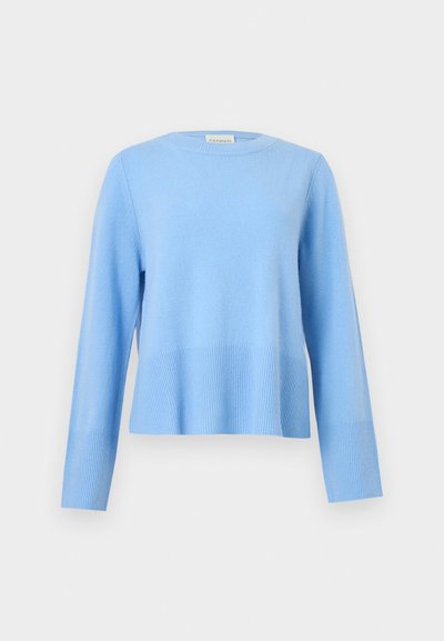 Ανοιχτό μπλε πουλόβερ με στρογγυλή λαιμόκοψη, μακριά μανίκια και ριμπ μανσέτες και τελείωμα σε απλό γκρι φόντο.