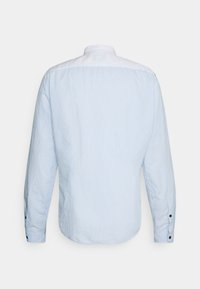 Camicia a maniche lunghe azzurro chiaro con yoke bianco. Presenta un motivo a righe sul corpo e bottoni neri sui polsini. Texture liscia.