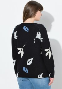 Schwarzer Pullover mit floralen Mustern in Weiß und Blau, Rundhalsausschnitt, langen Ärmeln und einer weichen Stricktextur. Sichtbare Nahtdetails.