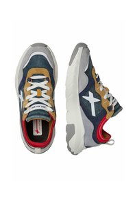 Sneakers con un design multicolore che presenta materiali blu navy, grigi e beige. Lacci bianchi, suola in gomma e accenti rossi sul colletto.