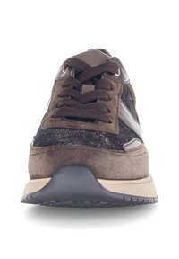 Bruine suède en lederen sneakers met een gestructureerde bovenkant, ronde veters, eengevoerde zool en contrasterende grijze strepen aan de zijkant.