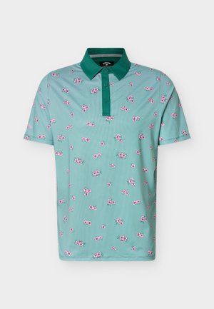 Světlomodrá krátký rukáv polokošile s tmavě zeleným límečkem a knoflíkovou légou, ozdobená malými růžovými květinovými vzory po celé ploše.