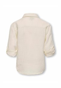 Krēmbalti krekls ar brīvā piegriezuma, pogātām jostām un sarullētām piedurknēm. Ar struktūru veidota auduma, garāks aizmugurējais apmale un smalkas satīna detaļas.