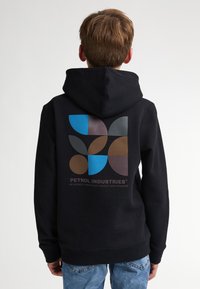 Zwarte hoodie met een groot geometrisch ontwerp in blauw, bruin en grijs op de rug. De stof lijkt zacht en heeft een grote voorste kangoeroezak.