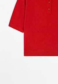 Polo shirt a maniche corte rossa in maglia, con polsini e orlo a coste e tre bottoni al collo, su uno sfondo bianco.