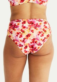 Högmidjad bikiniunderdel i en färgglad blommig design med röda, rosa och gula blommor på en ljus bakgrund. Mjuk, elastisk tyg.
