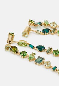 Bracciale con chiusura dorata che presenta molteplici gemme verdi in diverse forme e dimensioni, tra cui tagli ovali, rettangolari e marquise.