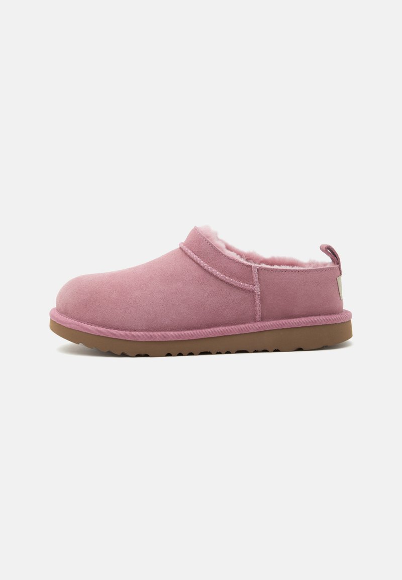 Chausson rose doux à enfiler avec doublure en peluche et semelle en caoutchouc marron, conçu pour le confort et la chaleur en intérieur, vue de profil sur fond blanc.