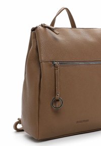 Pruunist tekstuuriga nahast seljakott, millel on ülemine käepide, eest tõmblukuga tasku ja rõngasaktsent tõmbluku lähedal. Tugev disain igapäevaseks kasutamiseks.