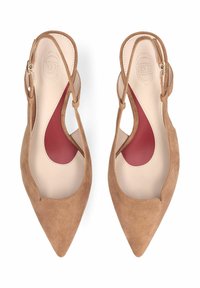 Chaussures plates à bout pointu en daim marron avec bride arrière, semelles intérieures beiges et inserts de soutien de la voûte plantaire rouges, vues de dessus sur fond blanc.