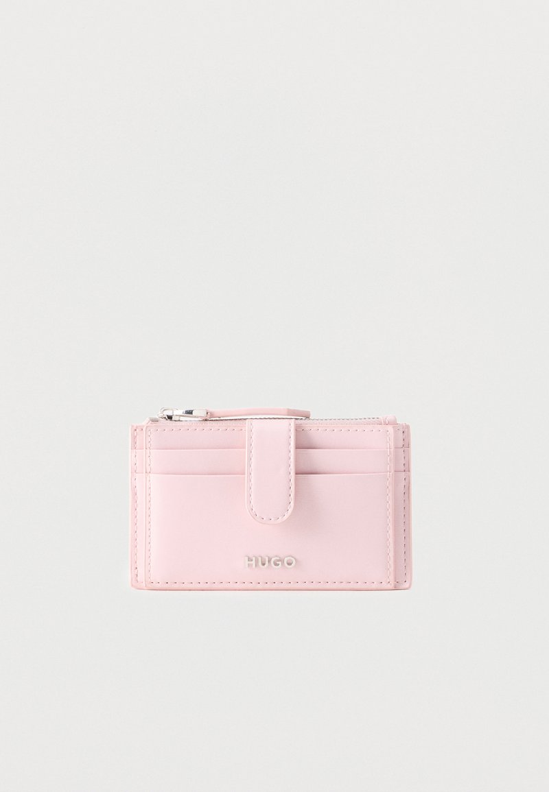 Portefeuille compact en cuir rose clair avec emplacements pour cartes, poche zippée, fermeture pression et logo « HUGO » embossé à l'avant.