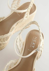 Sandales compensées tissées beige avec brides à la cheville et semelles intérieures rembourrées étiquetées « NEXT Forever Comfort » en taille 6½ largeur large.