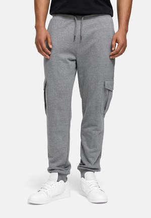 Gray sweatpants in soft cotton blend, featuring side cargo pockets, elastic cuffs, and a drawstring waist, paired with white sneakers.