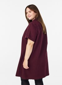 Robe bordeaux à manches courtes en coton, avec une coupe décontractée, un col rond et un ourlet arrivant au genou, à la texture lisse.