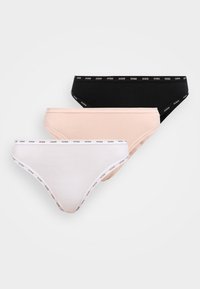 Trois culottes bikini en coton pour femmes en noir, beige et blanc, chacune avec une ceinture et une bordure estampillées « GUESS ».