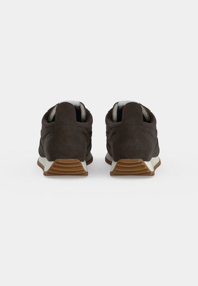 Paire de baskets en daim brun foncé vues de dos avec semelles intermédiaires blanches et semelles extérieures en caoutchouc brun sur fond blanc.