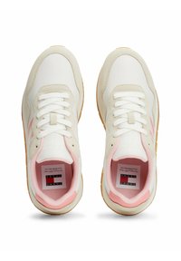 Zapatillas blancas y beige que presentan una franja de acento rosa, material texturizado, forma redonda y cordones blancos. Suela de goma con un patrón sutil.