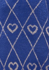 Blauwe stof met een ruitpatroon omlijnd in beige, elke ruit bevat een klein beige hartje in het midden.