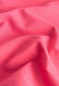 Erksin korallivärvi kangas, millel on sile, veidi läikiv tekstuur, esitades pehmeid kortse ja ühtlast venivust materjalis.