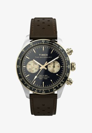 Timex Waterbury chronograafhorloge met een zwarte wijzerplaat, gouden accenten, een zilveren roestvrijstalen kast en een bruine geperforeerde leren band.