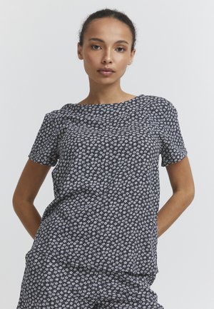 T-shirt à manches courtes en tissu bleu foncé avec un motif floral blanc. Encolure ronde, coupe décontractée et texture douce, idéale pour un usage quotidien.