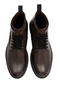 Brązowe skórzane botki na kostkę o teksturowanej powierzchni, czarne sznurowadła i zamek po obu stronach. Posiadają miękką brązową podszewkę oraz gumową podeszwę.