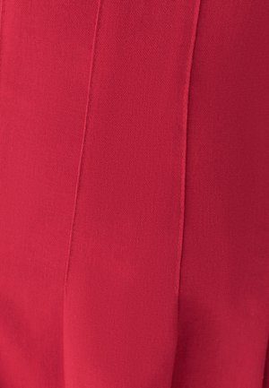 Tessuto a maglia rosso con una texture liscia, caratterizzato da dettagli delle cuciture verticali. Il colore è vibrante e uniforme, senza modelli o accenti visibili.