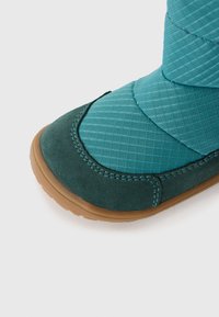 Stivale alla caviglia color teal con tomaia in tessuto texturizzato a strisce diagonali, dettagli in camoscio e suola in gomma per una migliore trazione.