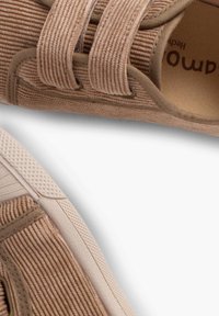 Baskets en toile beige avec un design texturé à côtes, dotées de deux bandes élastiques et d'une semelle en caoutchouc solide avec un motif en diamant.