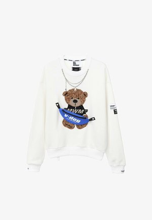 Sudadera blanca con un gráfico de oso de peluche texturizado, cadenas superpuestas y un detalle de riñonera azul con el texto "v.dog".