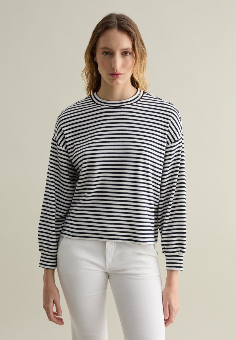 Maglietta a maniche lunghe a righe in blu navy e bianco, scollatura rotonda, vestibilità rilassata, tessuto morbido, con maniche leggermente arricciate e orlo corto.