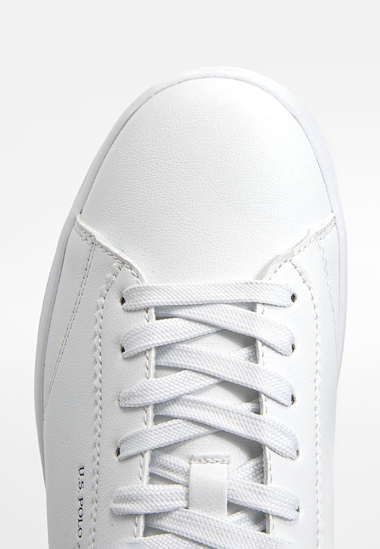 Sneaker bianca in pelle con una finitura liscia, dotata di lacci piatti bianchi, punta arrotondata e dettagli del logo laterale. Design e texture minimalista.