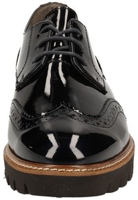 Chaussure habillée en cuir verni noir avec un design à bout fleuri, détails perforés, bout arrondi, lacets gris et semelle épaisse en bois.
