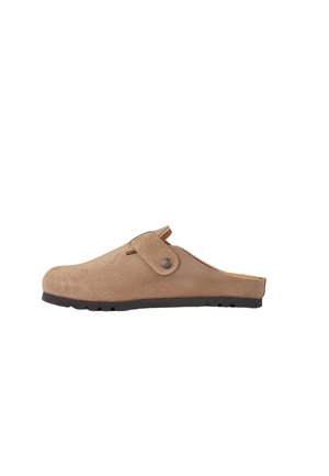 Zoccolo beige in pelle scamosciata con cinturino regolabile e suola in gomma nera, mostrato di profilo su sfondo bianco.