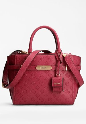 Red Guess handbag with embossed logo pattern, dual handles, adjustable shoulder strap, and attached small pouch with gold-tone hardware.