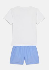 T-shirt en coton blanc à manches courtes associé à un short bleu clair. Le t-shirt a un col rond simple et le short est doté d'une taille élastique.