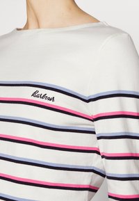 Weißes Langarmoberteil mit horizontalen Streifen in Marineblau, Hellblau, Rosa und Dunkelrosa. Besticktes "Barbour" auf der Brust.