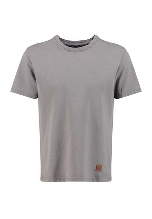 Prosty szary t-shirt z krótkim rękawem i okrągłym dekoltem, z małą brązową skórzaną łatą w pobliżu dolnego brzegu na białym tle.