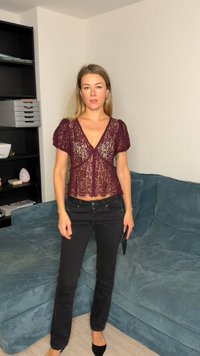 Top in pizzo bordeaux con maniche corte a sbuffo, scollo a V e orlo smerlato. Abbinato a jeans neri a gamba dritta e scarpe nere con punta appuntita.