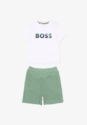 T-shirt blanc à manches courtes avec le texte "BOSS" en vert et bleu, associé à un short à taille élastique vert clair avec des poches avant.