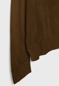 Tissu de pull en tricot marron montrant un motif texturé avec poignets et bord côtelés sur un fond clair.