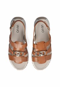 Brown leather sandals with a strappy design, featuring a silver buckle accent and a textured light-colored outsole. Brand logo inside.