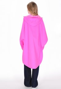 Világos rózsaszín vízálló poncsó kapucnival, hosszú ujjakkal és kényelmes szabással, ívelt szegéllyel és sima textúrával.