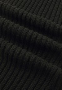 Tecido de malha preto com uma textura canelada, exibindo riscas verticais e uma aparência suave e aconchegante. Sem detalhes ou adornos adicionais.