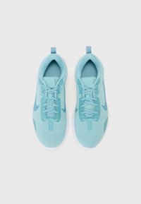 Baskets de sport bleu clair avec un dessus en maille texturée, des lacets plats et des semelles en caoutchouc blanc. Logo Nike en bleu foncé sur chaque chaussure.
