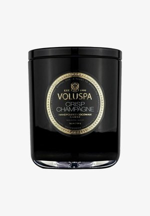 Sort glaskrukke til stearinlys med et guldetiket med teksten "VOLUSPA CRISP CHAMPAGNE." Håndhældt cocowax, 9,5 oz. Cirkulært design, blank finish.