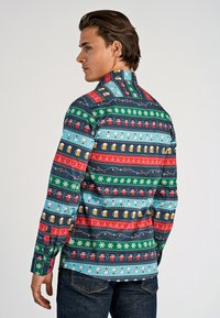 Langarmshirt met een kleurrijk patroon van mokken, sneeuwvlokken en feestelijke ontwerpen op een donkere achtergrond, met een kraag.